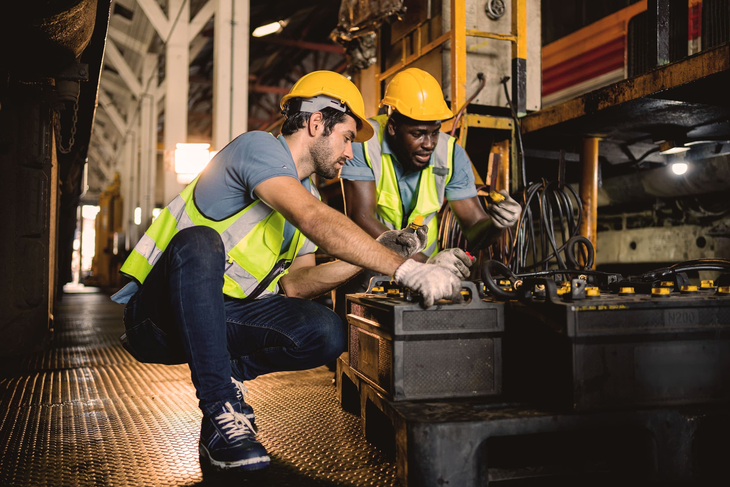Workers repairing mechanical components in an industrial workshop setting